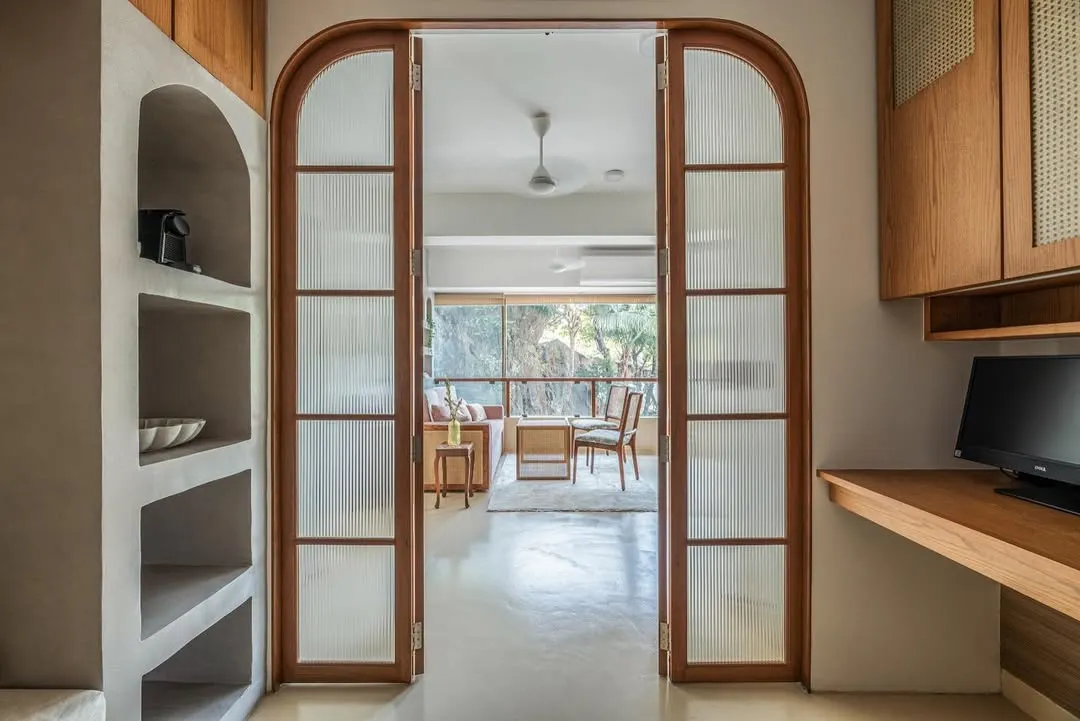 I love creating spaces that can adapt to your life. For this nutrition clinic, I designed these arched, fluted glass doors to beautifully separate the main living area from the workspace, allowing it to transform into a cozy bedroom at night.