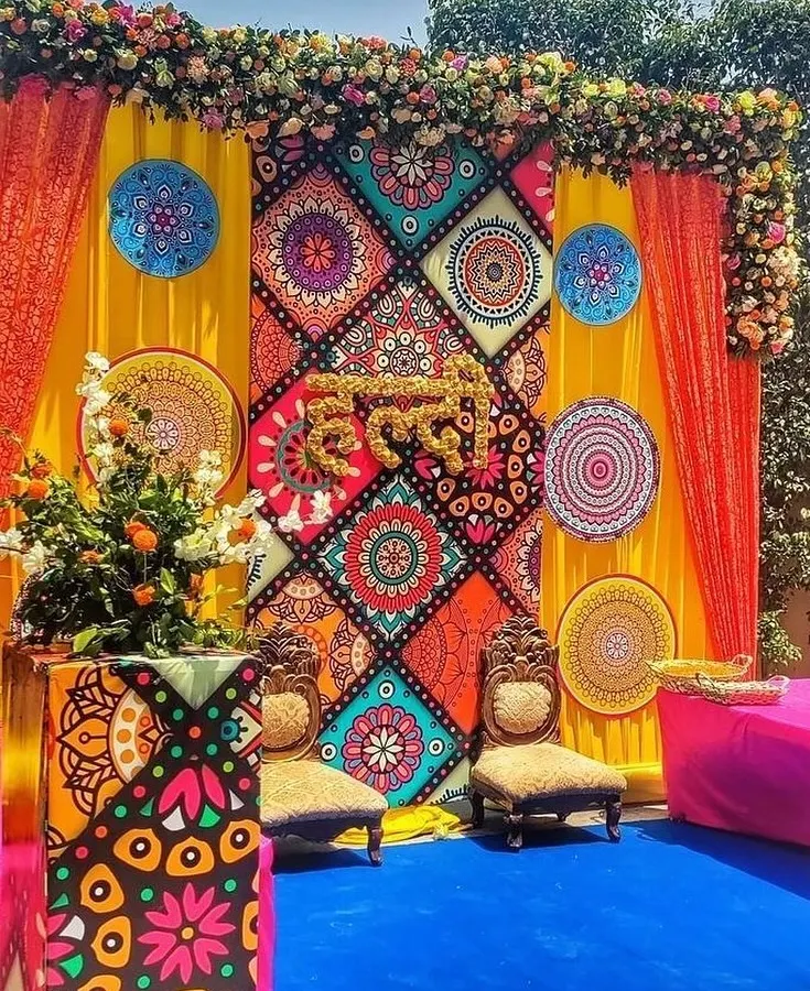 This is not your average Haldi decor. For this event, we designed a vibrant, Rajasthani-inspired backdrop using colorful printed panels, mandala art, and the word "Haldi" crafted from fresh marigold flowers. It’s a perfect example of how we mix traditional elements with modern design.