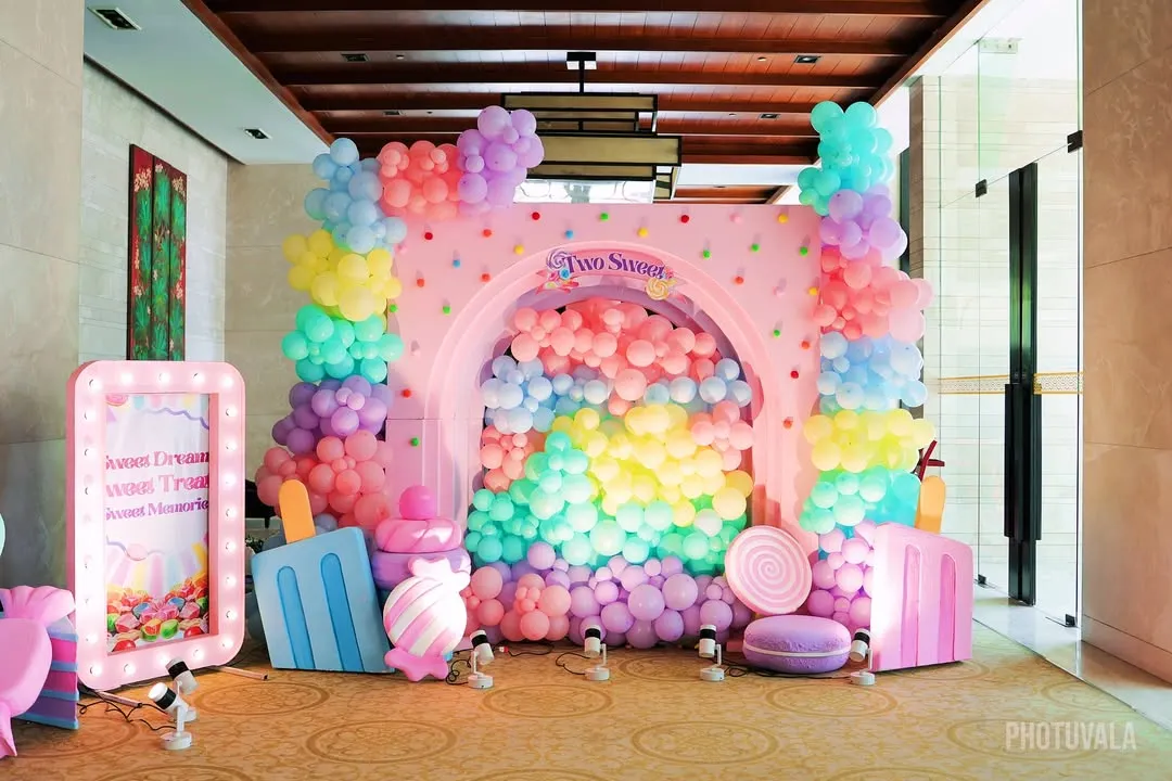 I designed this vibrant Candyland themed photo booth as a sweet spot for pictures. It features a cascade of pastel balloons pouring through an arched backdrop, surrounded by giant lollipops, ice cream props, and a custom light up sign.