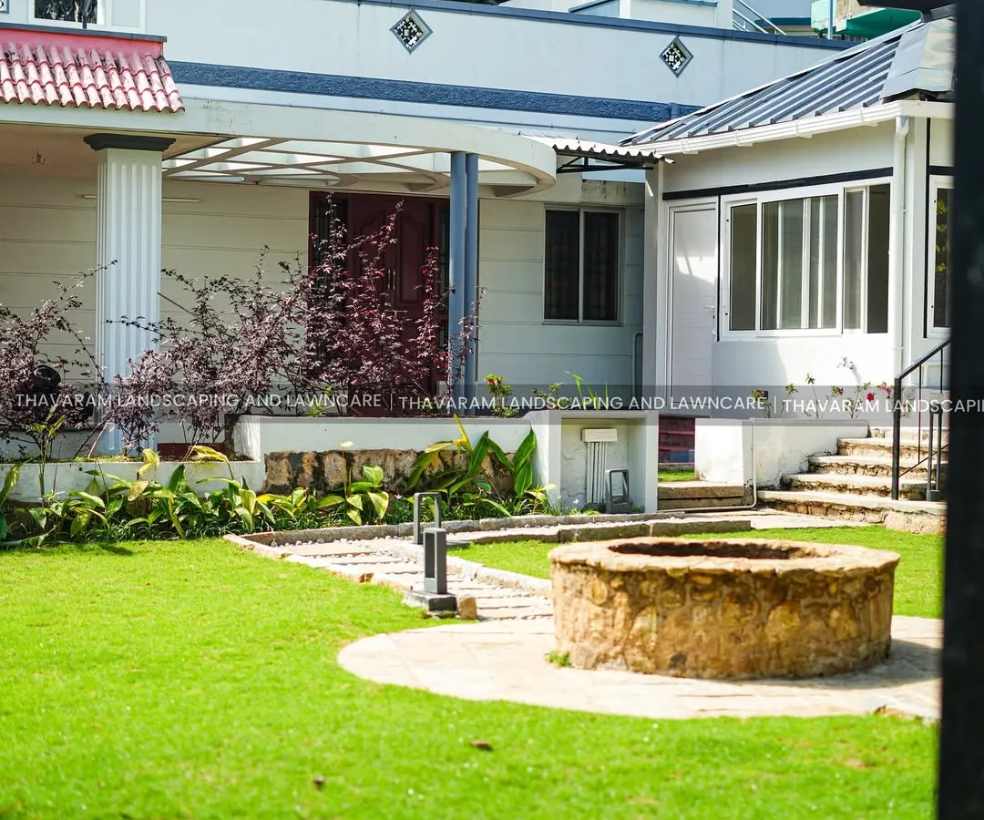 I design complete residential landscapes that feel like a private retreat. Here, a healthy, expansive lawn is the centerpiece, complemented by a rustic stone well, carefully planned garden beds, and pathways that invite you to explore the space.