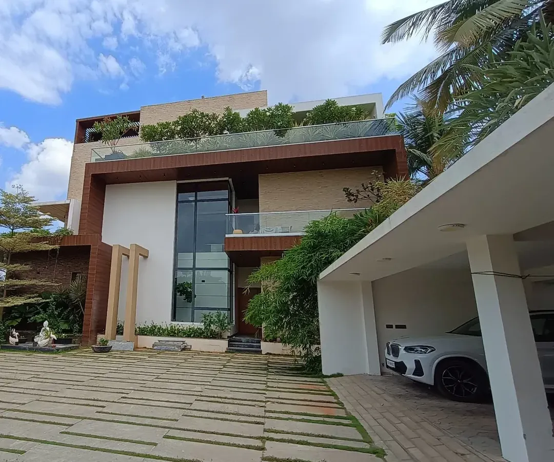 This is a full view of a modern residential landscape I designed and installed. The project features a stone paver driveway, carefully selected trees, and layered garden beds that complement the home's architecture, a project that has now matured over five years.