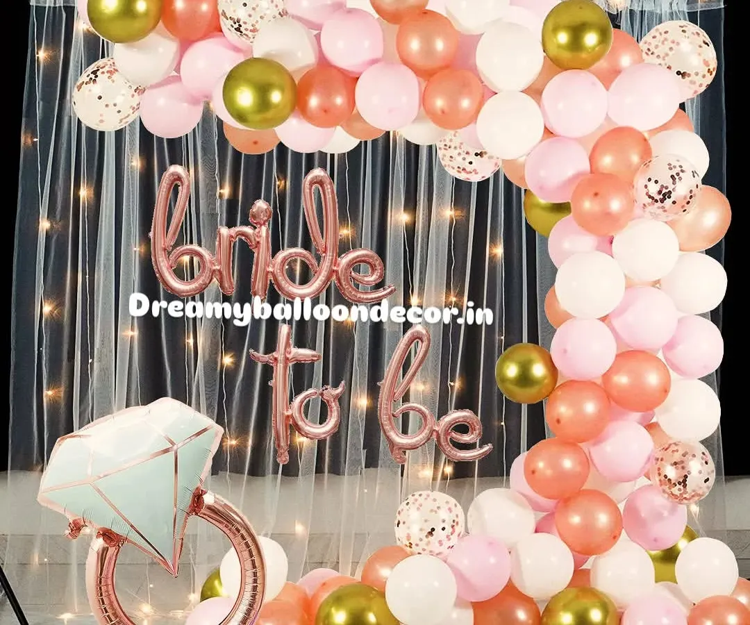 I create stunning, Instagram-worthy backdrops for 'Bride to be' parties. This popular rose gold theme features a full balloon arch with confetti and chrome accents, a shimmery curtain, and a giant diamond ring foil balloon for the perfect photo opportunity.