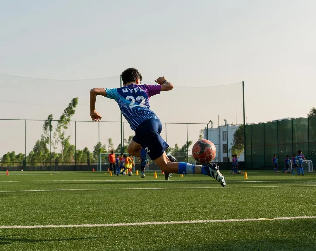 Flying high! This shot captures the power and technique we instill in our players. It's about giving everything in every moment, reaching for that spectacular goal.