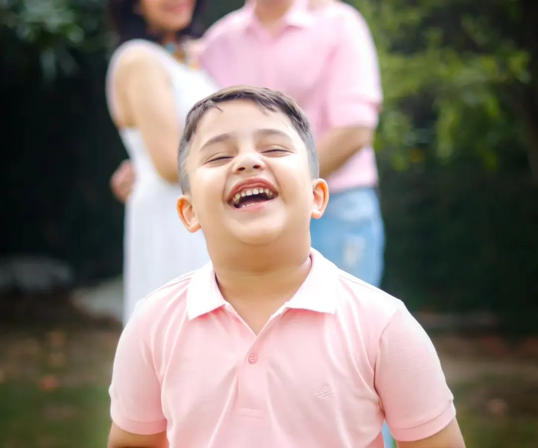The pure excitement of a boy about to become a big brother, with his parents looking on with so much love. This is a pregnancy announcement filled with genuine, heartfelt emotion.