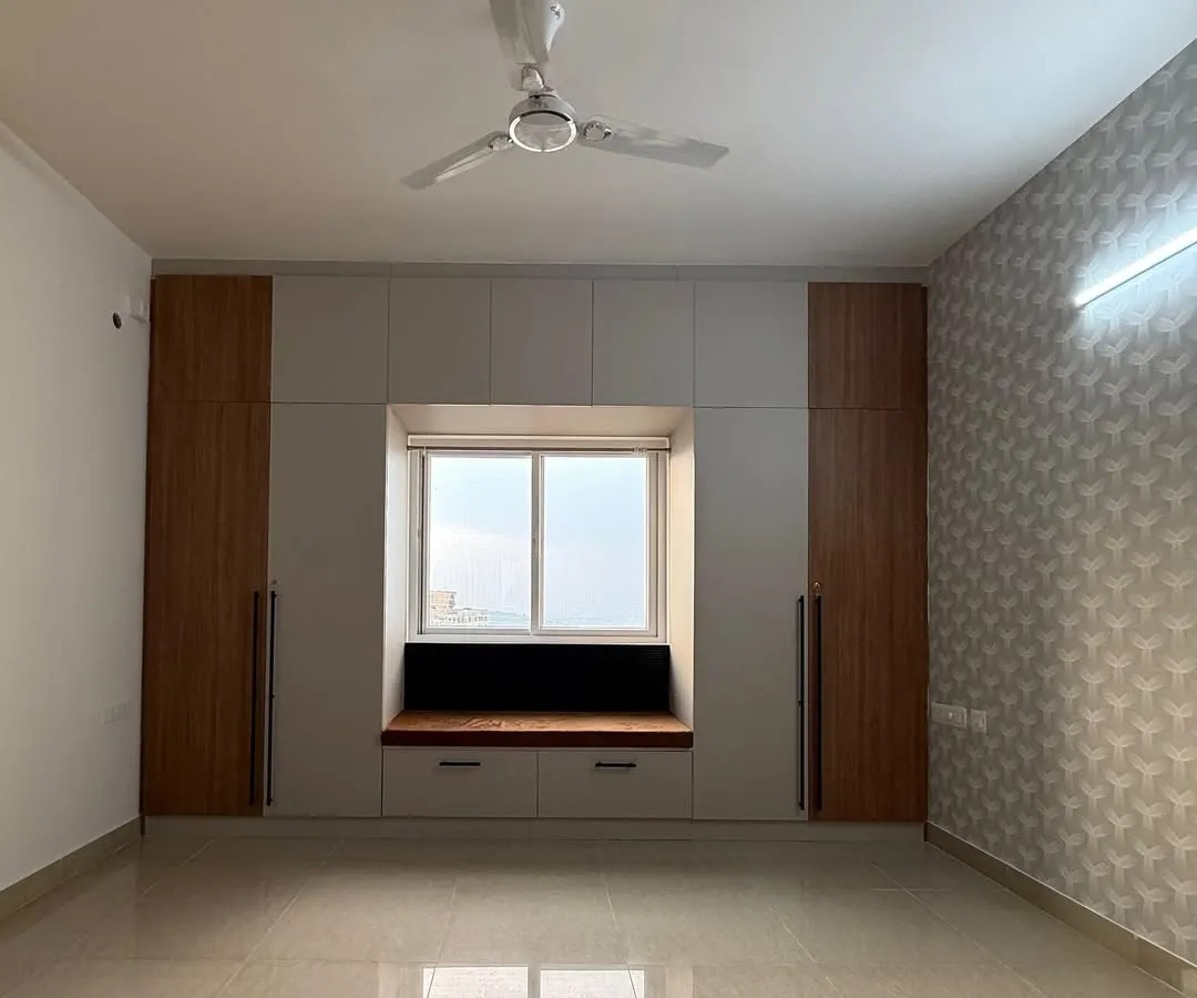 We believe every corner of a home should be useful and beautiful. This bedroom features a custom-built window seat with integrated storage, creating a perfect nook for reading or enjoying the view. It’s these personal touches that transform a room.