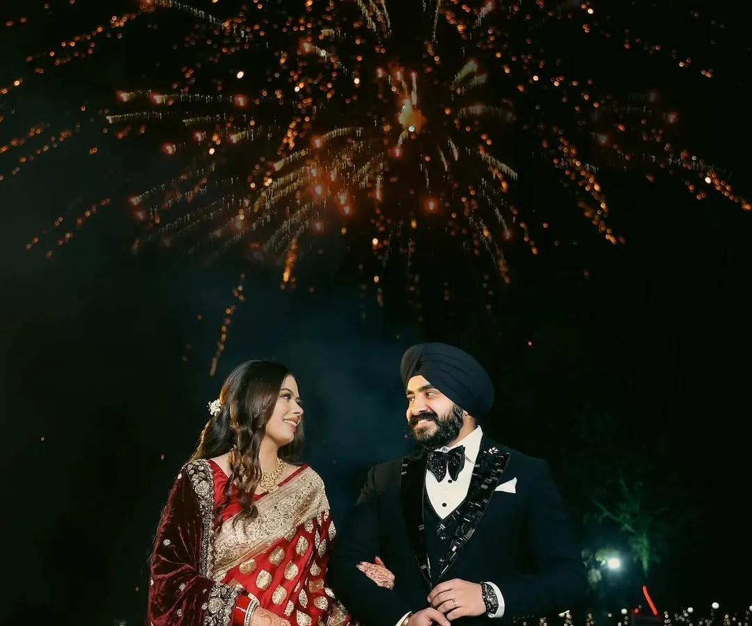 A magical reception night captured under a sky full of fireworks. I focus on framing these grand celebrations to feel both spectacular and deeply personal, highlighting the couple's joy amidst the sparkle.