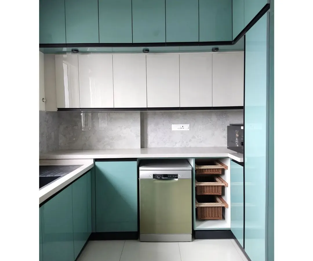 A modern kitchen is a blend of clean aesthetics and smart functionality. This bespoke kitchen in a vibrant teal features high-gloss cabinetry, integrated appliances, and ample counter space, designed for a seamless culinary experience in a contemporary Bengaluru home.