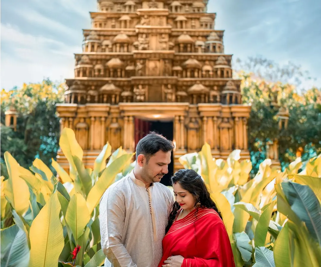 Blending tradition with the grandeur of nature, this outdoor maternity shoot at a temple is for those who want to celebrate their roots. The vibrant red saree against the ancient architecture creates a powerful and divine portrait of love and new beginnings.