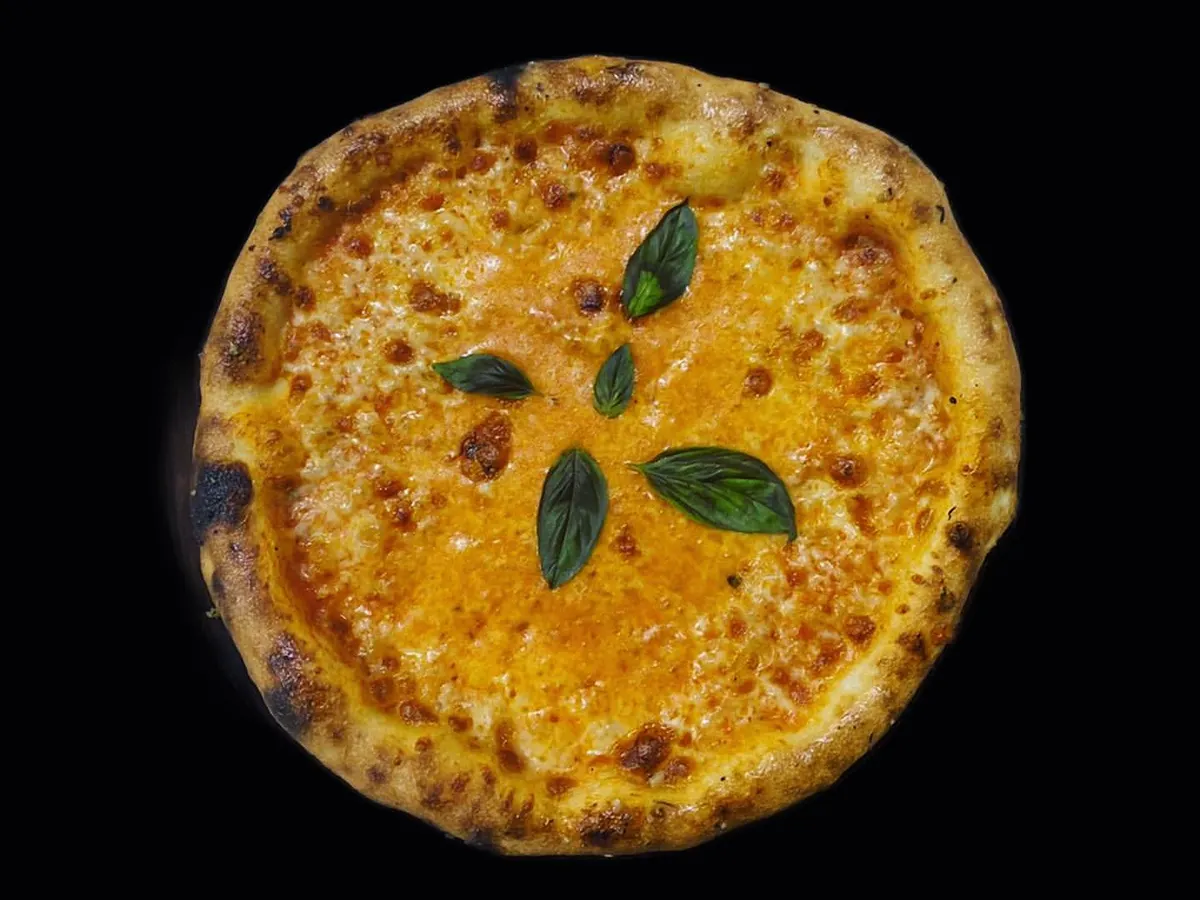 A look at our classic Margherita pizza, fresh from the oven. We use premium cheese and fresh basil for an authentic Italian taste that is always a crowd pleaser at parties and corporate events.