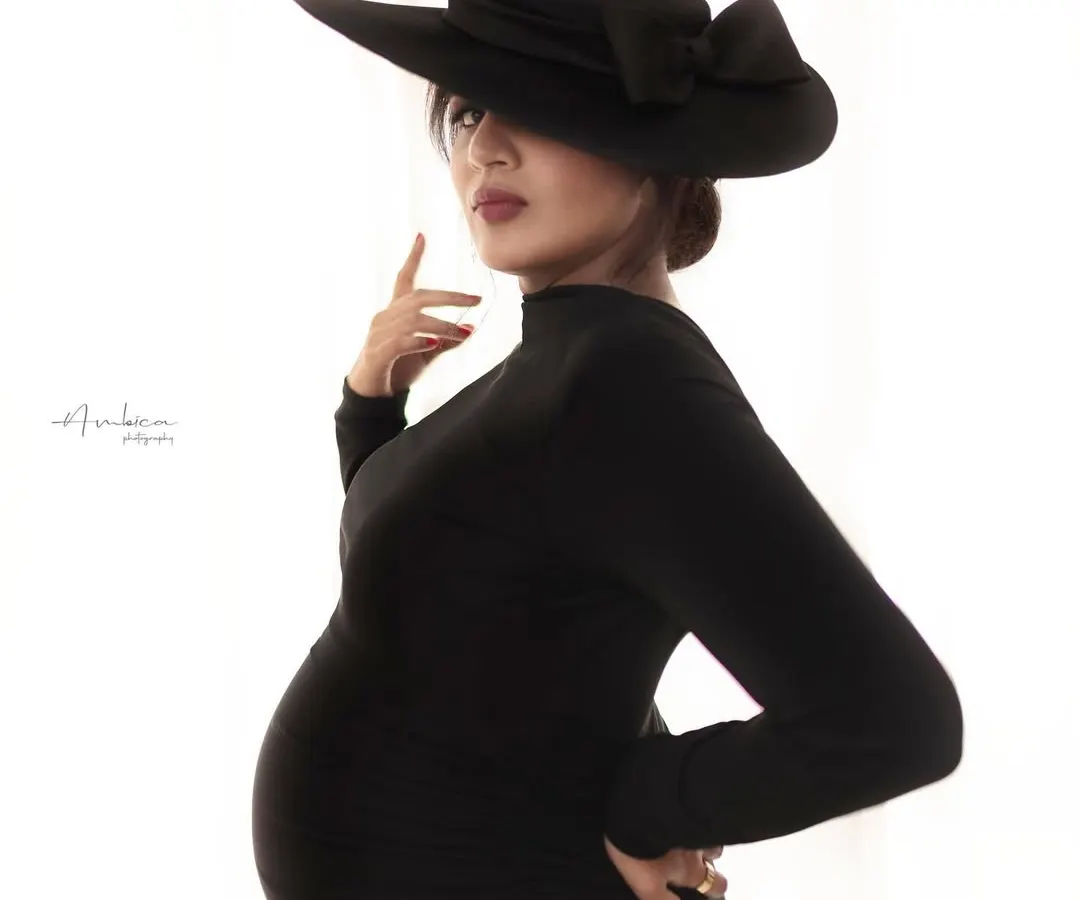 A modern take on maternity, this portrait is for the woman who is bold and chic. We collaborated on this high-fashion concept, using a striking black dress and hat to create a powerful, elegant silhouette that celebrates pregnancy with confidence and style.
