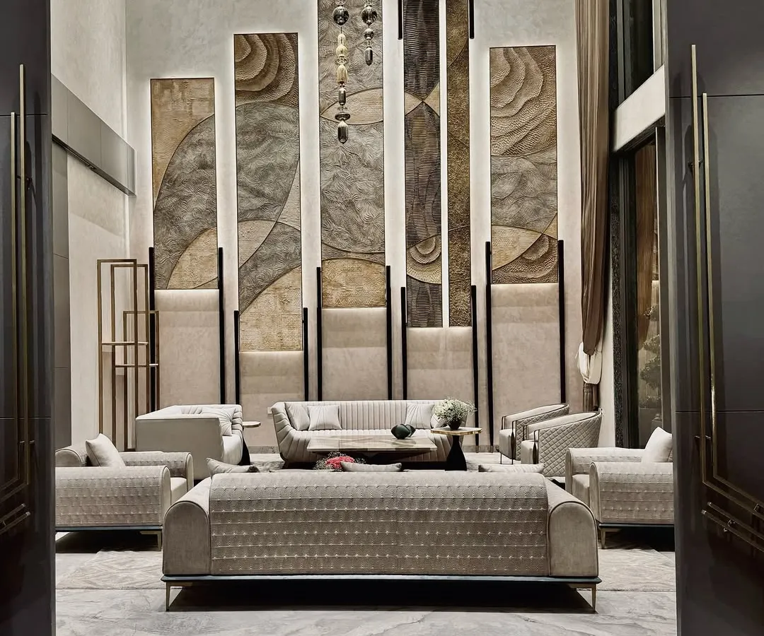 This double-height living room is a study in verticality and texture. We used towering, backlit panels with organic patterns to draw the eye upward, creating a sense of grandeur, while the plush, contemporary sofas arranged for conversation provide a grounded, comfortable core to the space.