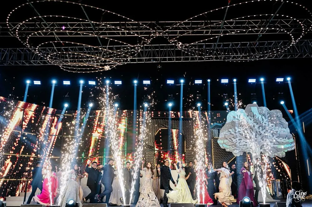 This is how we end a sangeet night, with a grand finale that brings everyone together. This shot captures the explosive energy of a full-family performance, complete with perfectly timed pyrotechnics that light up the stage and create a memory for a lifetime.
