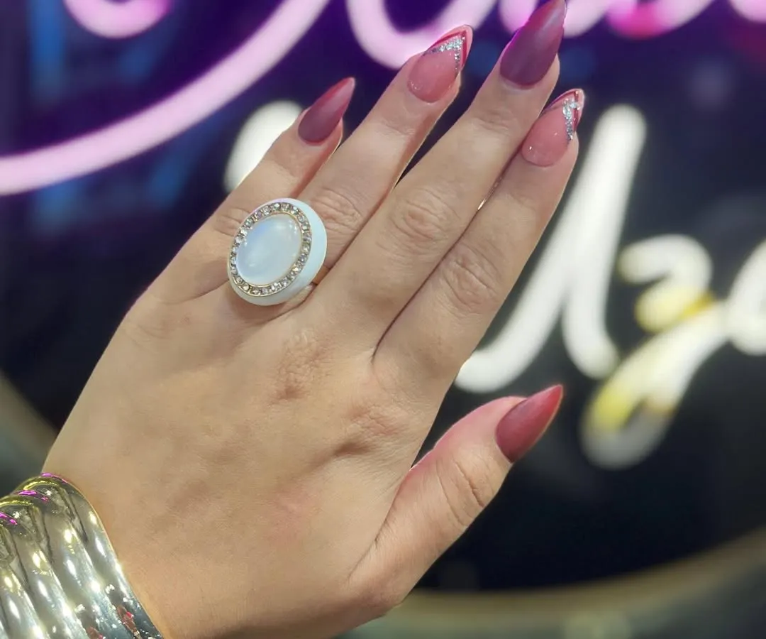 Make a statement with this custom stiletto nail set. The design combines a matte mocha base with a deep red, accented by a reverse French tip in sparkling silver glitter for a bold, high-fashion look.