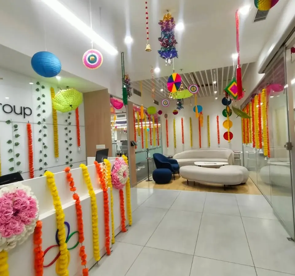 We transform everyday office spaces for festive occasions. Here, a corporate reception area is decorated for Diwali using traditional marigold garlands, colorful paper lanterns, and hanging crafts to create a warm and celebratory atmosphere for employees and visitors.