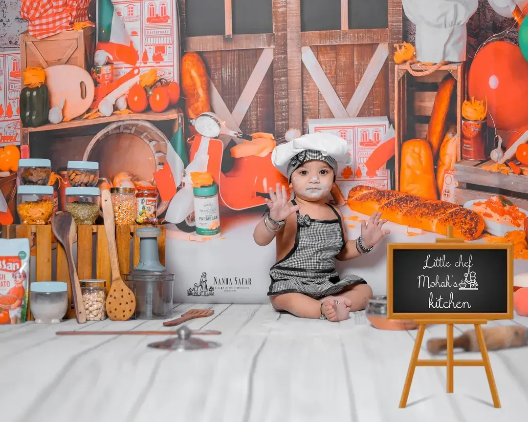 Welcome to the 'Little Chef's Kitchen'. This theme is all about fun and capturing candid moments as your baby plays with safe props like flour and toy food in a custom-designed kitchen backdrop.