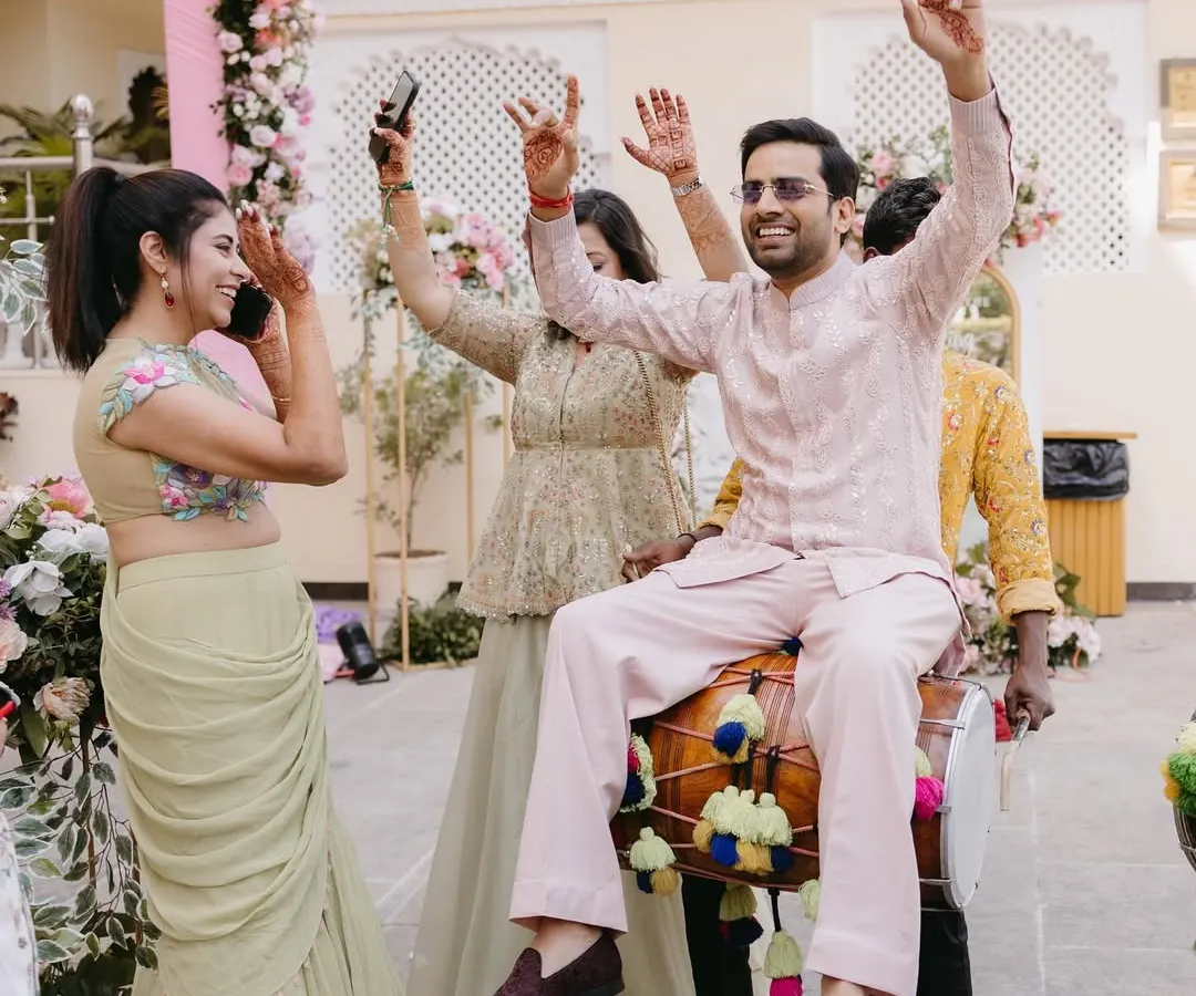 It's not just about the outfits, it's about the vibe. Here's groom Shivam, looking effortlessly stylish and having the time of his life at his Welcome Lunch in a custom pastel embroidered jacket and pants.