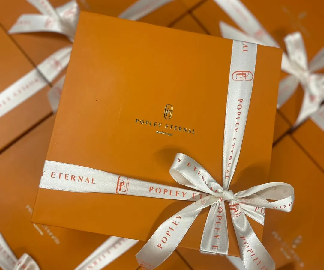 A great example of our custom branding work for a client. We designed these elegant corporate gift boxes with custom logo ribbons for Popley Eternal, ensuring their brand was front and center. I love making sure every detail, from the box to the bow, reflects your company's style.