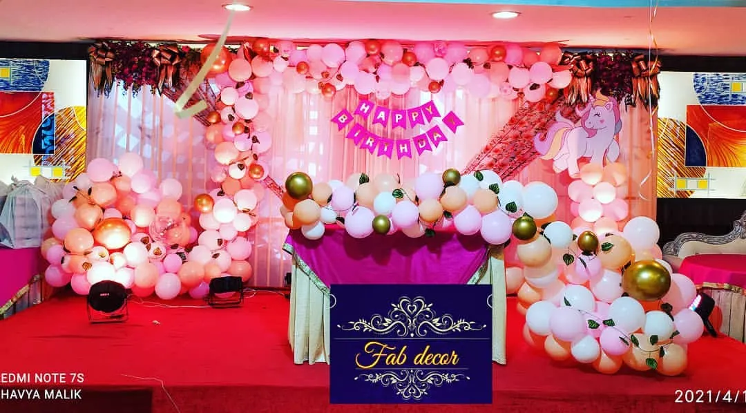 This is a popular unicorn-themed birthday party setup. I used shades of pink, white, and gold to create a magical atmosphere, complete with a full stage backdrop, organic balloon garlands around the cake table, and a unicorn cutout.