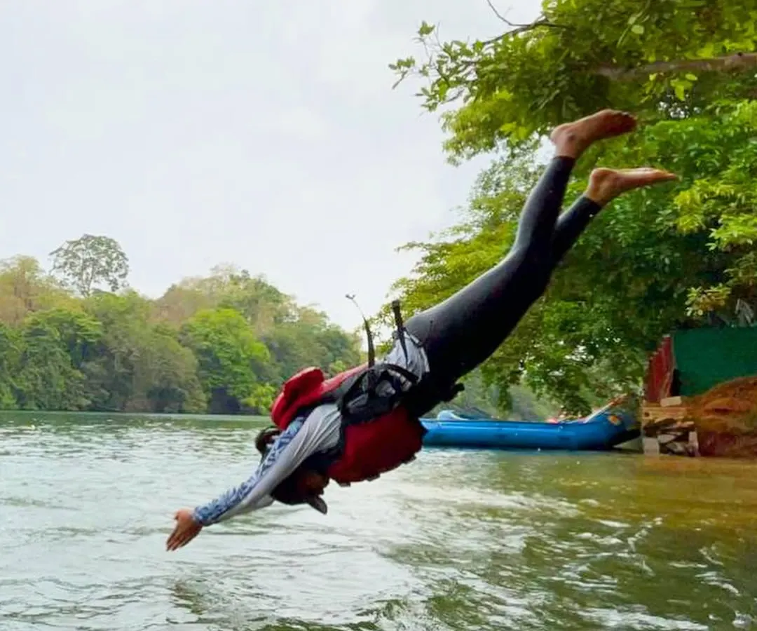 Sometimes the best part of the adventure is the pure, unscripted fun. Here, a participant takes a joyful leap into the cool waters of the Kali River during a break in our Dandeli rafting and kayaking course.