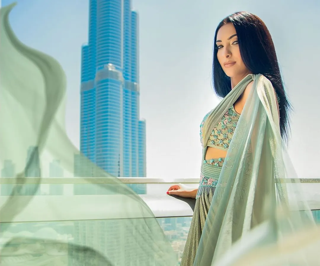 An international fashion shoot in Dubai, using the iconic Burj Khalifa as a backdrop. The flowing fabric of the gown adds a sense of motion against the cityscape, creating a high-fashion, aspirational image.