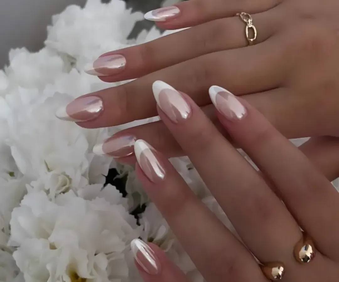 A modern take on a timeless classic. These elegant almond nails feature a pearlescent chrome finish over a natural base with crisp white French tips. This design offers a sophisticated and clean look, ideal for weddings, formal events, or elevating your everyday style.