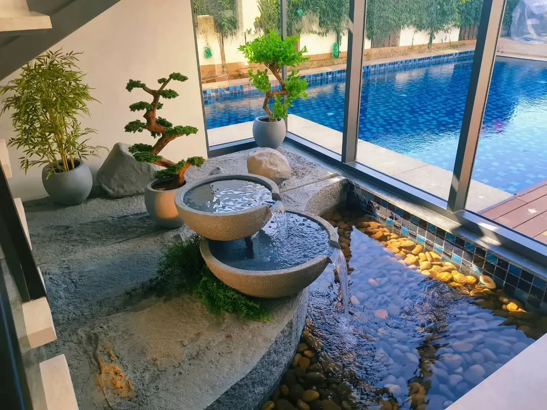 A closer look at the details of our indoor Zen fountain. We meticulously select and place each element, from the hand-finished stone bowls and natural river pebbles to the carefully chosen bonsai and bamboo plants, ensuring the feature integrates perfectly with your home's aesthetic.