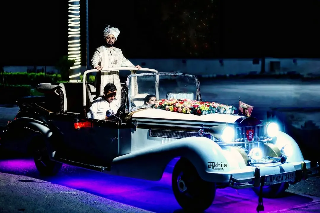 The groom's entry is a highlight of any Indian wedding, and I make sure to capture it with all its grandeur. This shot of the groom arriving in a vintage car, complete with dramatic lighting, shows my cinematic approach to documenting the baraat.