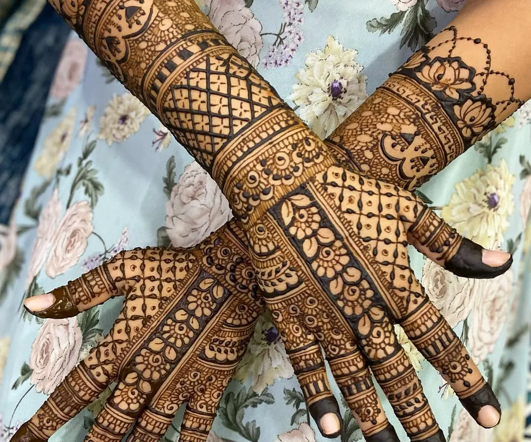 A full-coverage traditional mehandi design, showcasing intricate jaal (net) patterns, delicate floral work, and bold, clean lines. This style is perfect for anyone who loves a rich, detailed henna look.