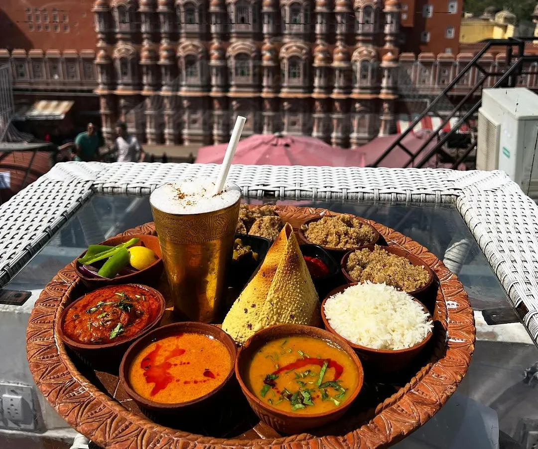 Food photography is not just about the dish, it's about the story. Here, a traditional Rajasthani thali is captured at The Tattoo Cafe, with the iconic Hawa Mahal creating a stunning, unforgettable backdrop that connects the food to its culture.