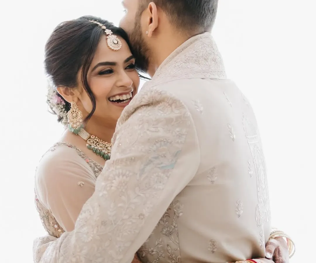 An intimate and joyful embrace between the bride and groom, showcasing a genuine moment of happiness and connection captured with a bright, airy feel.