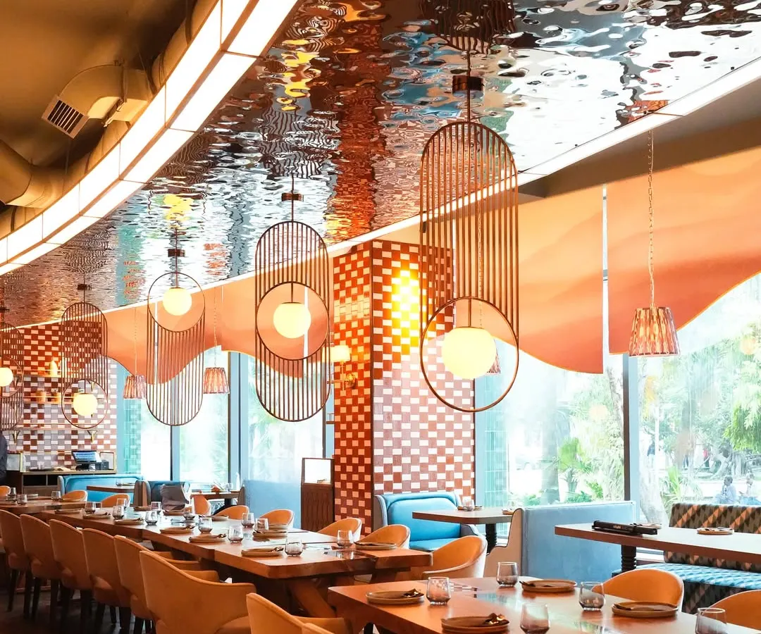 Welcome to our Mumbai dining room, a space designed for connection and celebration. The shimmering ceiling and warm lighting create an elegant yet comfortable setting, perfect for everything from a corporate dinner to a large family gathering.