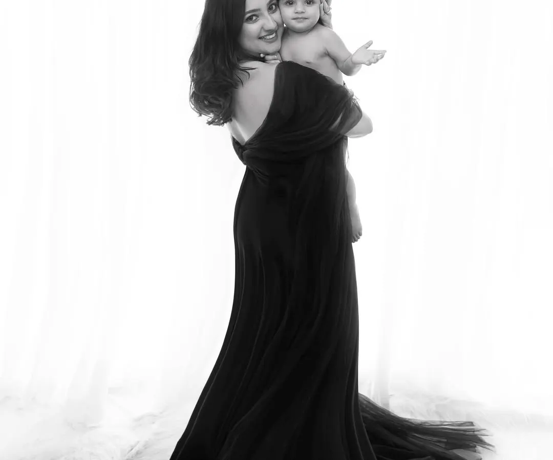 There is a unique power in monochrome. This mother and child portrait, styled in elegant black, showcases a timeless bond with a touch of fine art drama, a style I absolutely adore for its emotional depth.