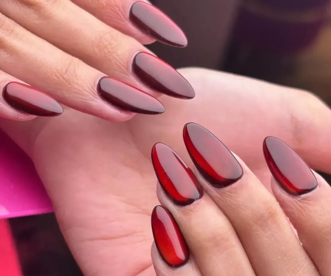 A close up of my deep cherry red jelly nails. This look is achieved by layering sheer gel polish to create a glossy, translucent effect that has incredible depth, perfect for a bold yet sophisticated statement.