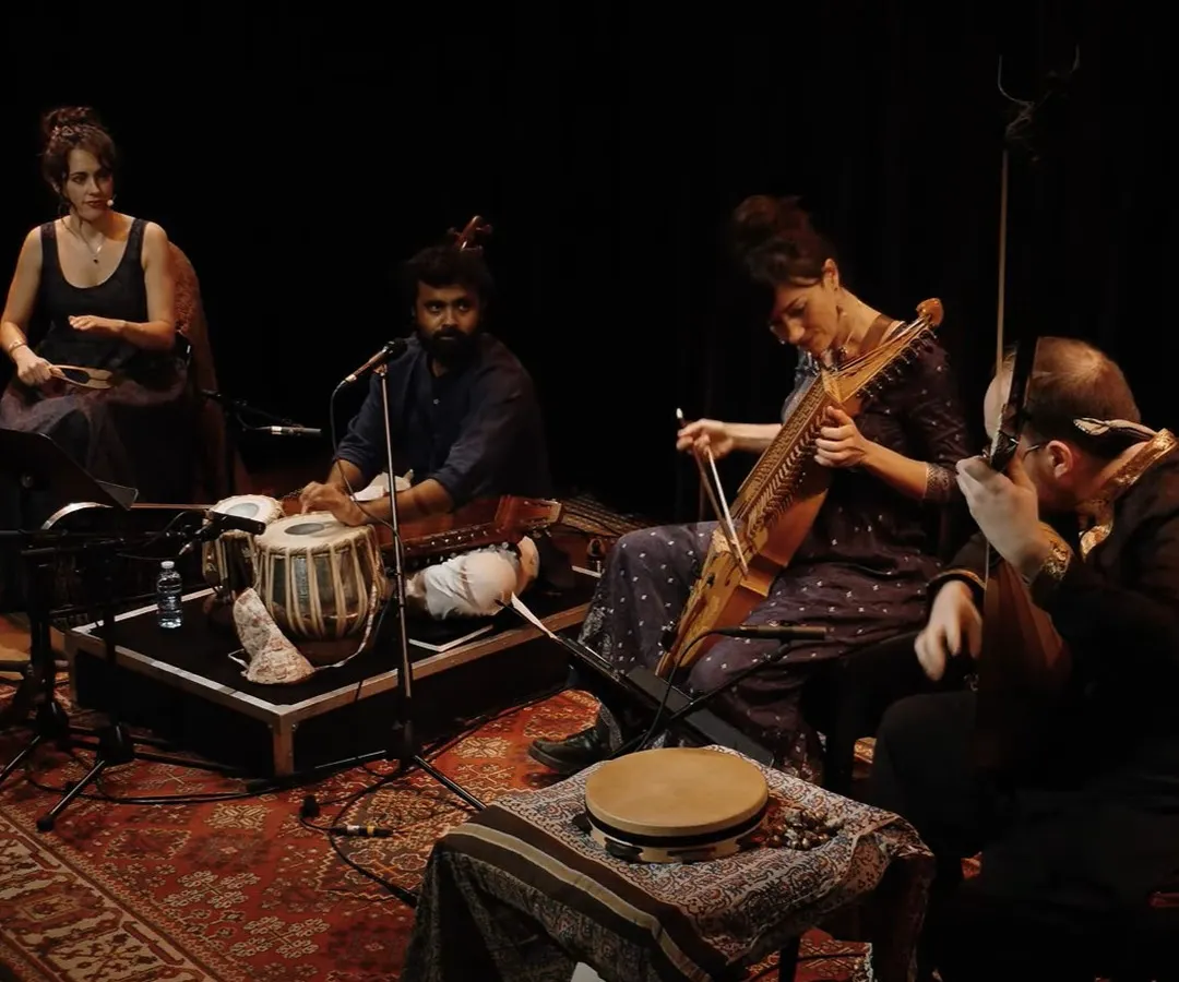A moment from our 'Sangam, Confluences' performance. This image showcases the heart of our musical fusion, with artists playing the Indian Tabla and the Swedish Nyckelharpa side-by-side in an intimate, dramatic setting.