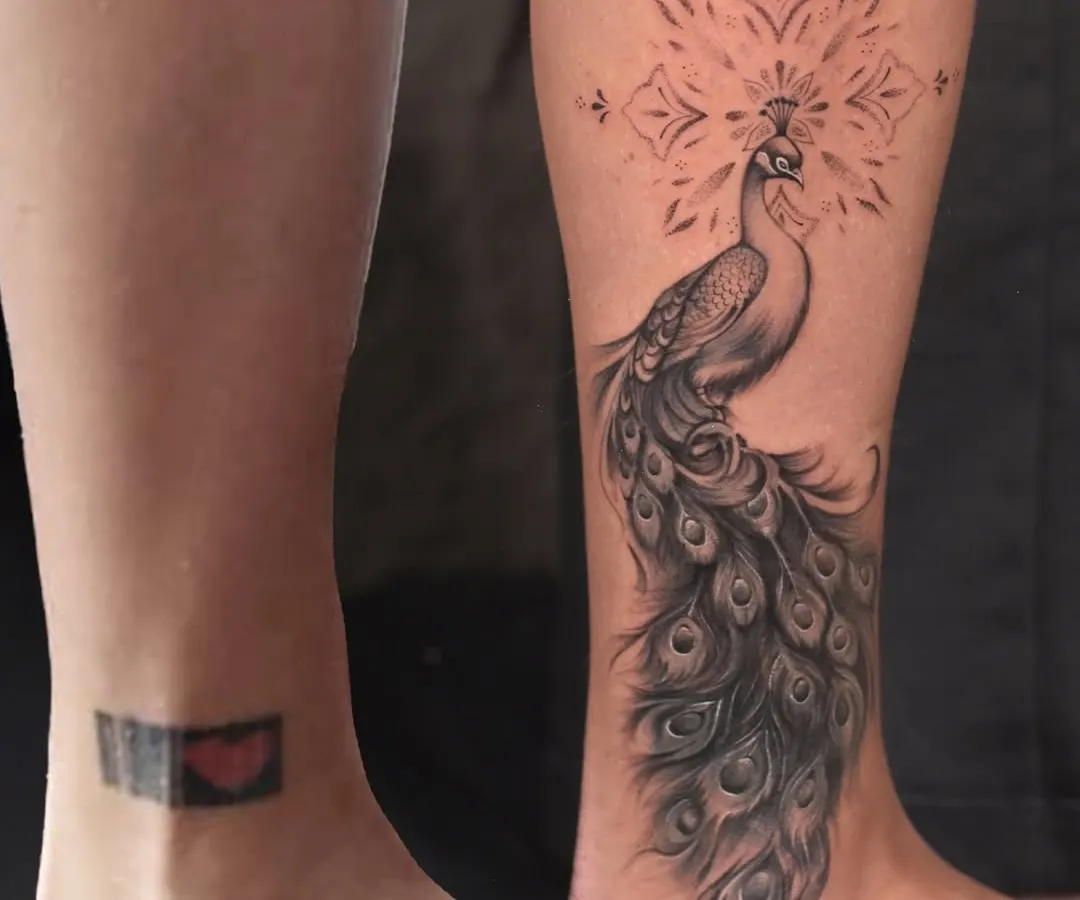Even a small, dark tattoo can be completely hidden. I designed this elegant peacock to flow with the ankle, turning an old memory into a beautiful, detailed masterpiece.