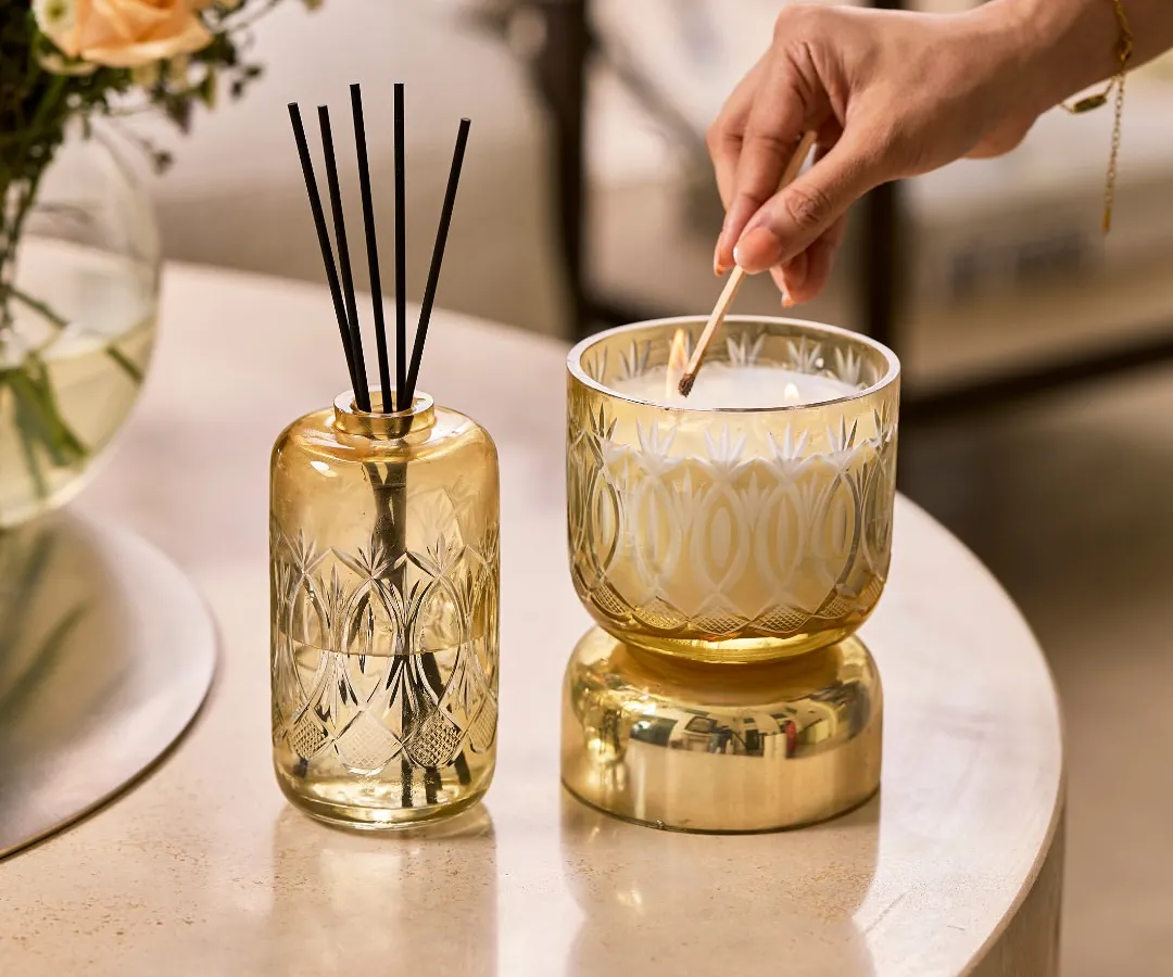 I believe in rituals, like the simple act of lighting a candle. Here, my Royal Haze candle and reed diffuser sit side by side, their hand-etched glass and golden hue bringing a touch of palatial elegance to a quiet moment. This set is perfect for creating a consistent layer of the rich Oud Bazaar fragrance in your living space.