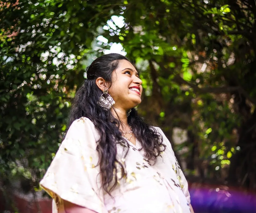 This is a portrait of pure joy. We used the natural garden light and a subtle lens flare to create an artistic, dreamy photo that captures the mother-to-be's happiness and excitement. This style of solo maternity portrait focuses on authentic emotion.