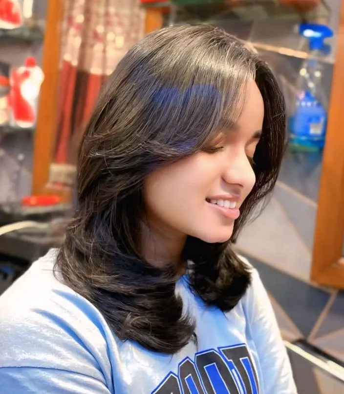 This is the result of a perfect layered haircut with feathered ends. The style adds incredible volume and movement, and the blowout styling makes the layers stand out beautifully.