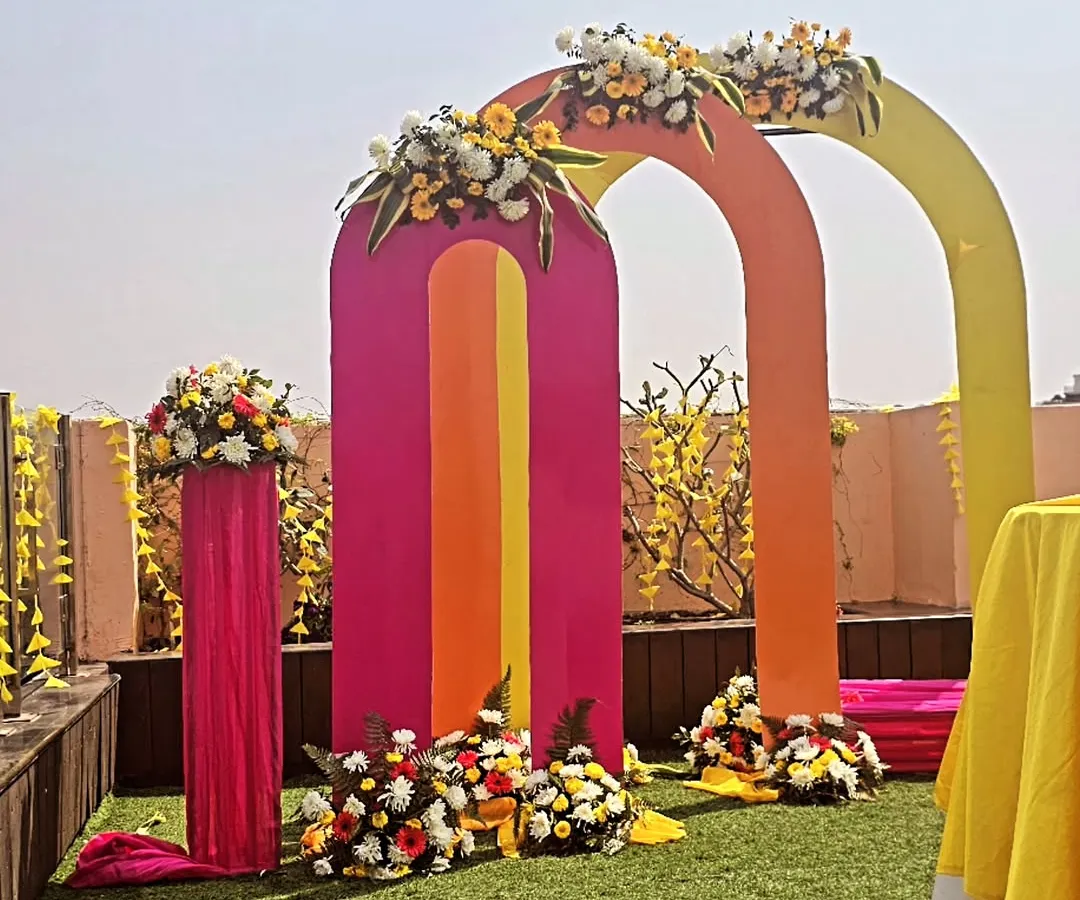 Planning a fun, modern haldi ceremony? We love playing with color, like these vibrant pink, orange, and yellow arches for a daytime garden event. This setup makes for incredible photos and a joyful atmosphere.