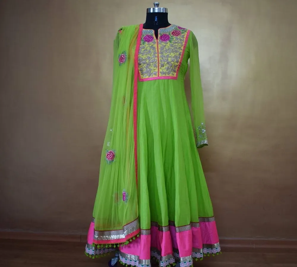 This vibrant lime green and pink Anarkali suit is perfect for the festive season. Made from flowing georgette with delicate floral embroidery and a matching net dupatta, it’s designed to make you stand out at any celebration.