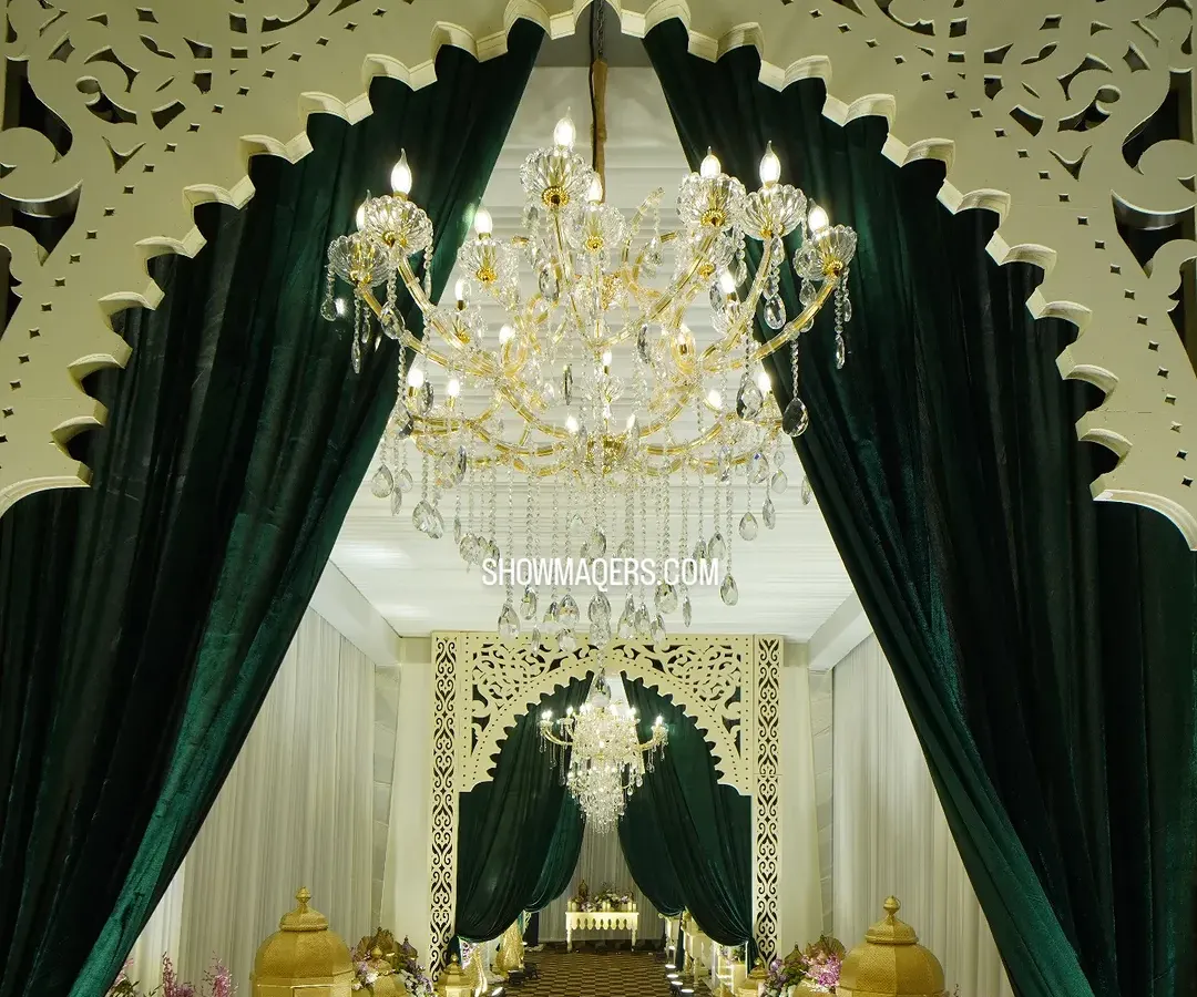 A grand entrance sets the tone for an exceptional event. For this evening gala, we created a stunning entryway with lush green velvet drapes, intricate laser-cut arches, and magnificent crystal chandeliers to welcome guests into a world of elegance.