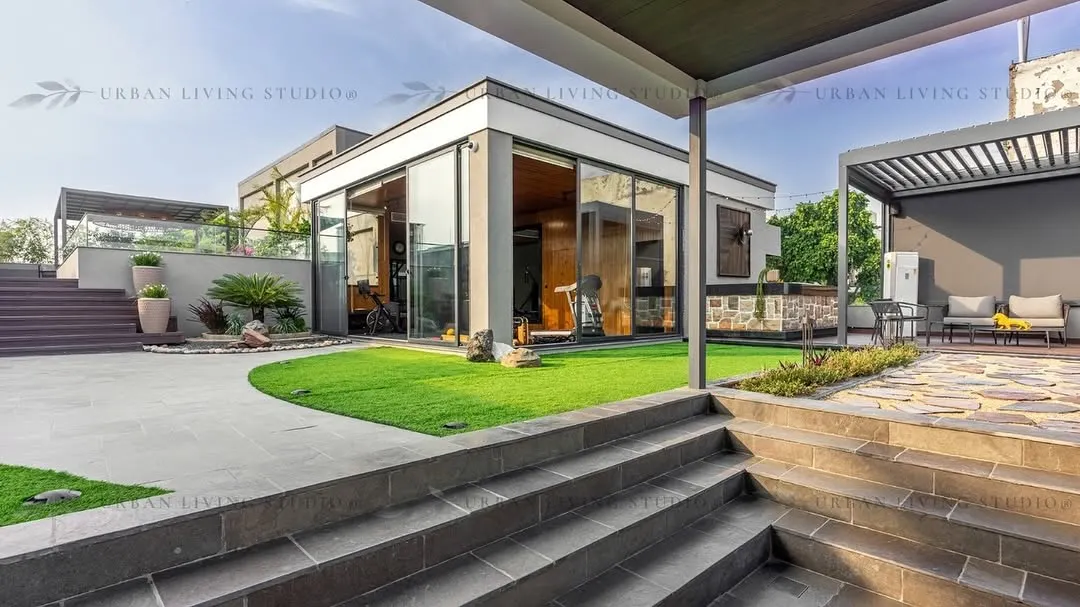 A wide view of our Aligarh project, showcasing how we design complete outdoor ecosystems. This space includes a glass-enclosed gym, a covered lounge area, and manicured lawns, all connected by thoughtfully designed pathways and multi-level structures.