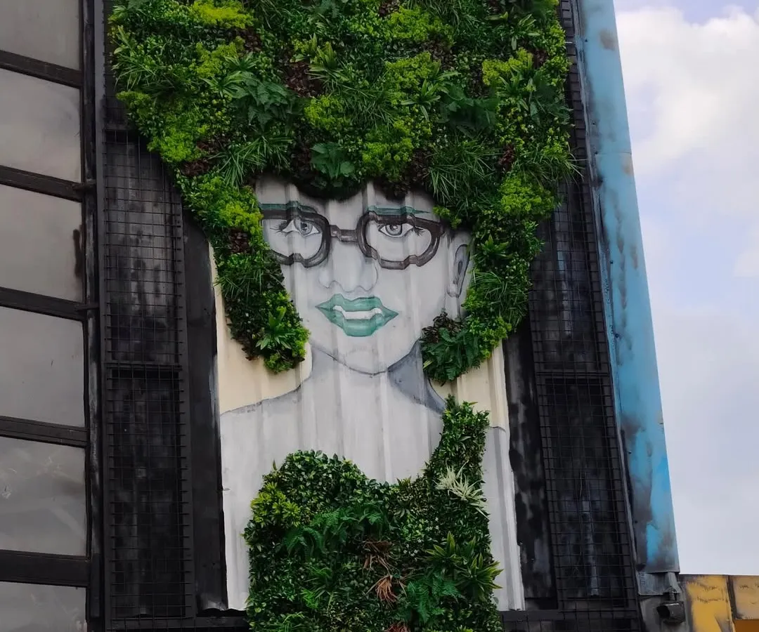 We go beyond simple green walls. This project at Bombay Adda shows our ability to create custom art murals, integrating greenery into a painted portrait to make a bold, unforgettable statement on a building's facade.