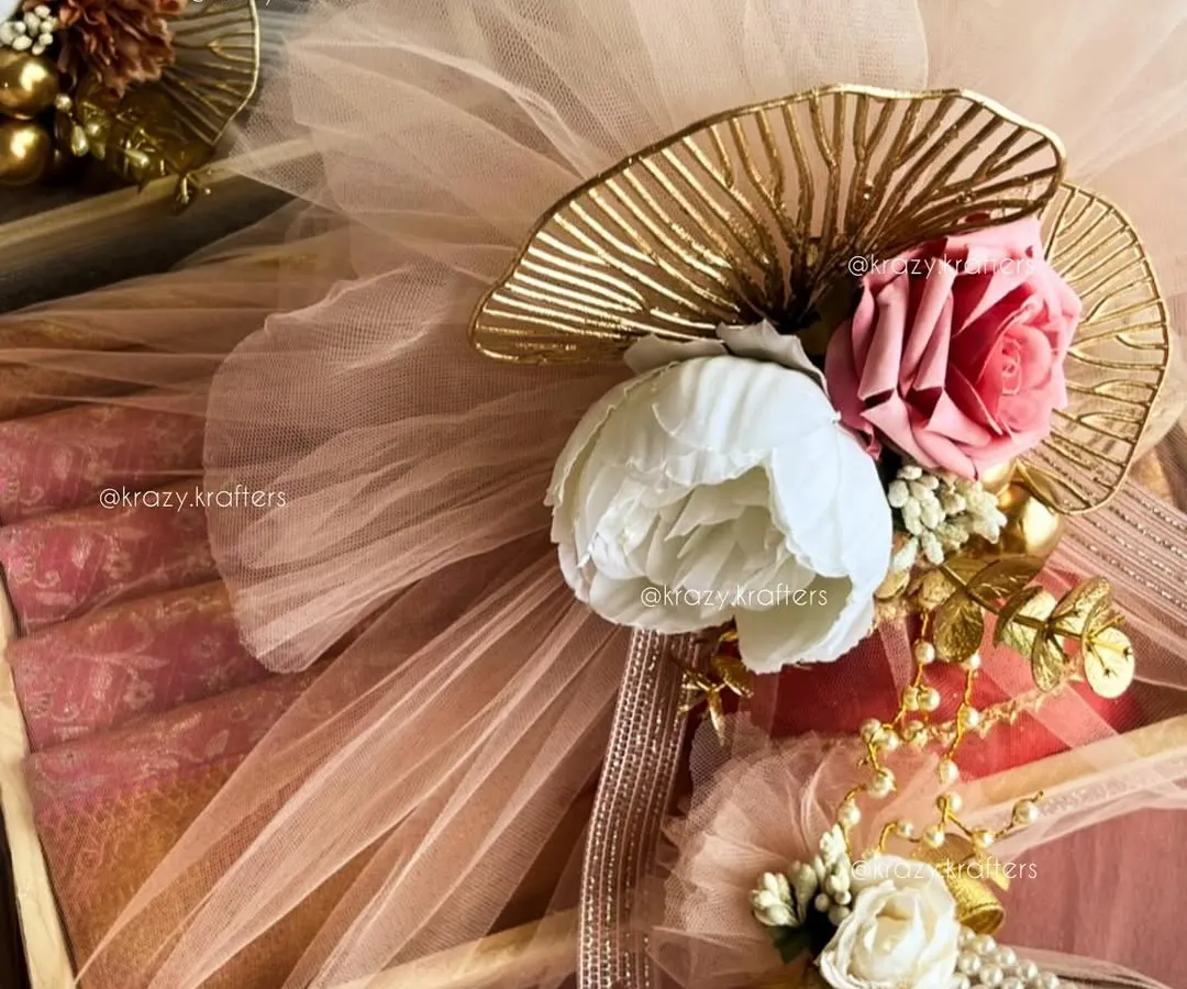 For me, trousseau packaging is an art. I combine elegant details like pastel net, artificial peonies and roses, and touches of gold to create a luxurious wrap for your wedding gifts that feels as special as the day itself.