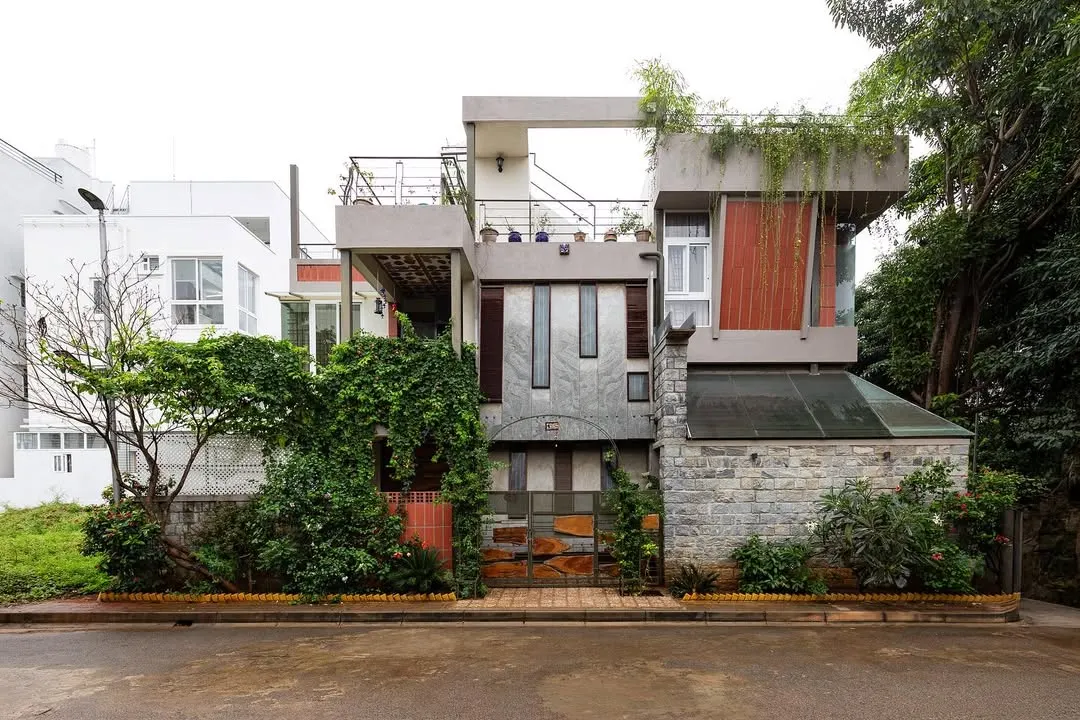 Here is the exterior of the same residence, showcasing how the interior's complexity is expressed on the facade. A mix of stone, wood, and glass is softened by cascading greenery, allowing the building to settle into its natural surroundings rather than impose on them.