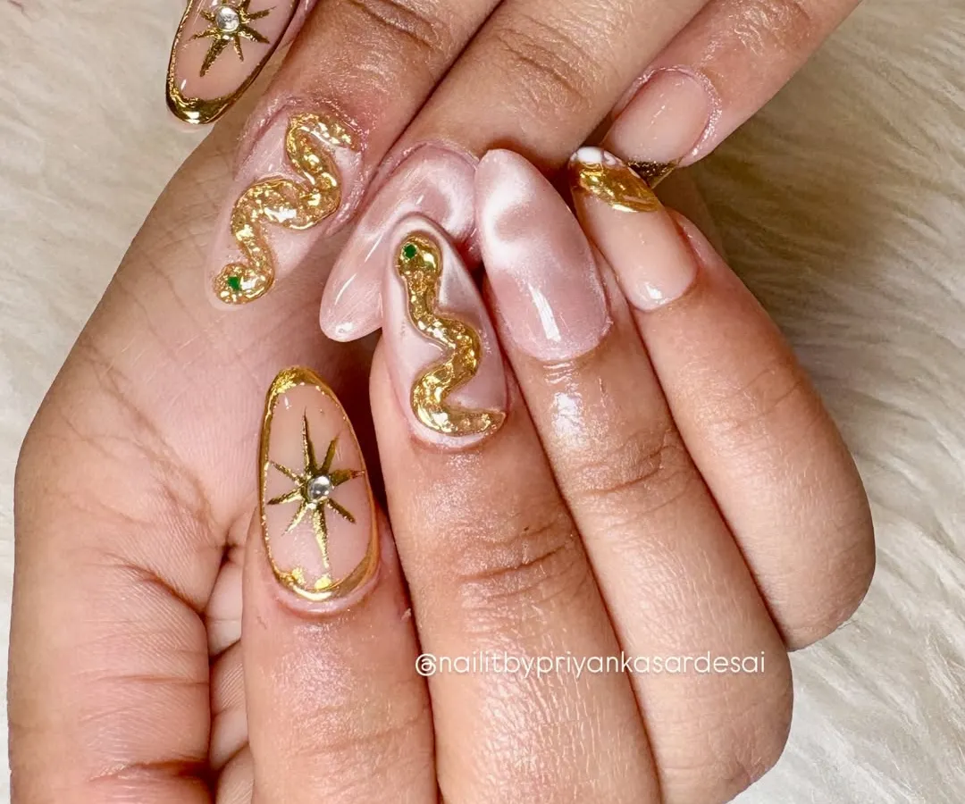 For the bold and celestial soul, this set features 3D sculpted golden snakes and starbursts on a soft, marbled nude base. I love creating these high-end, statement nails that are pure magic.