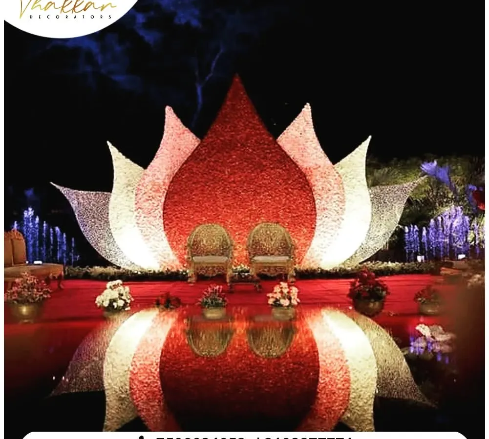 A magnificent reception stage designed with a larger than life lotus installation. The seating is framed by petals made of intricate floral work, creating a divine and royal focal point for the couple.
