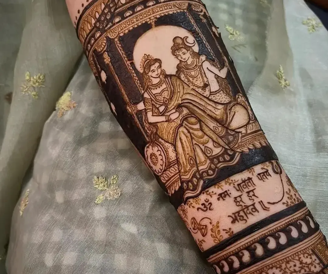 For brides who want a spiritual touch, I create divine portraits like this one of Shiva and Parvati on a swing. This image shows the design after the henna paste has been applied, with a sacred mantra written below to add a special blessing to the bridal art.