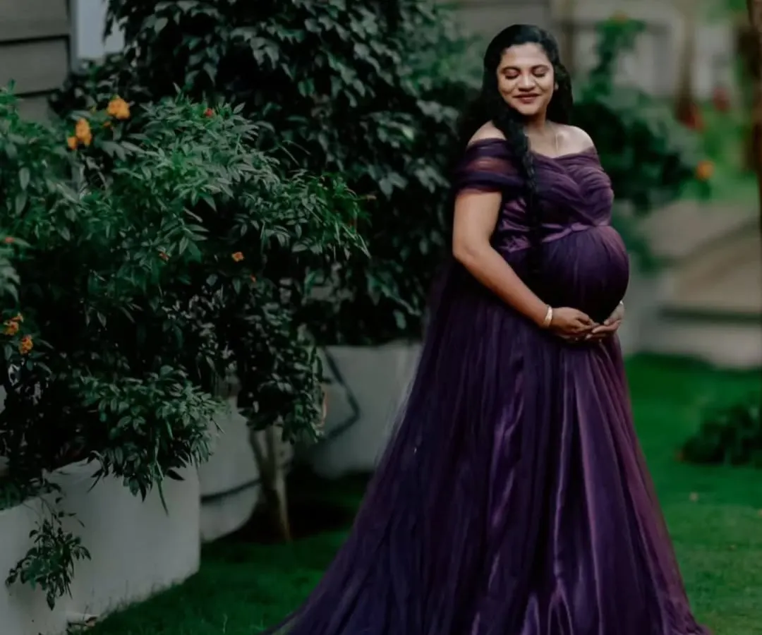 For all the moms-to-be, I design gowns that celebrate you. This deep purple off-shoulder maternity gown features a delicate tulle fabric and a long trail, creating a look of pure elegance for your maternity photoshoot.