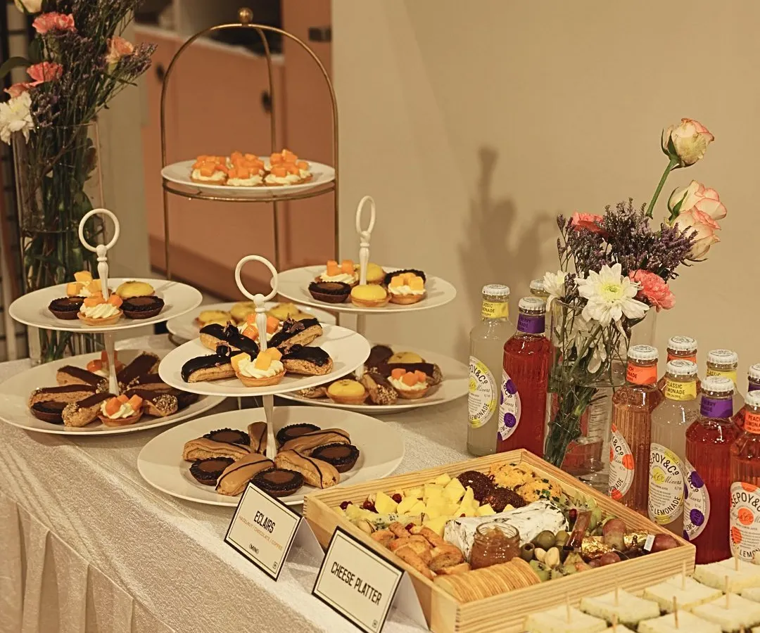 A beautifully arranged catering spread is art you can taste. For this event, I curated a selection of my finest offerings, including a custom cheese platter with artisanal crackers, delicate eclairs, mini fruit tarts, and refreshing beverages, all designed to impress guests at first sight.